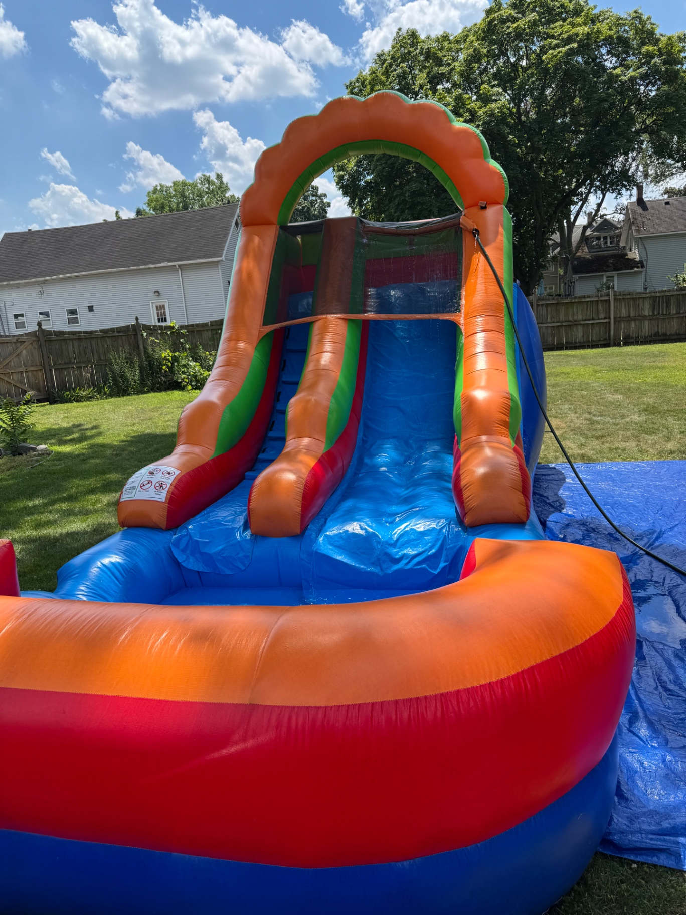 Front view of orange and blue inflatable water slide with splash landing